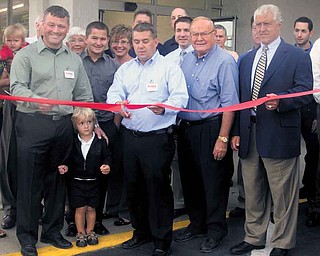 Save-A-Lot co-owner John Kawecki cuts the ribbon at the grand opening of the chain’s newest location, on Gypsy Lane near Belmont Avenue on Youngstown’s North Side. From left is co-owner Henry Nemenz Jr.; his son, Henry; Kawecki; Henry Nemenz Sr.; and Youngstown Mayor Charles Sammarone. The store is in the same location as the former Sparkle Market, which closed last year.