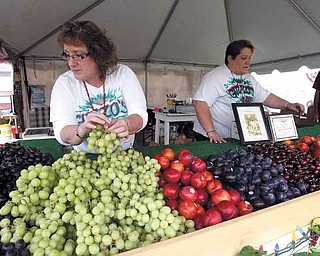 Ella Maria Guzzo-Welsh and Christina Guzzo perfect the fresh-fruit display their family has had for the more than 50 years at the Canfield Fair. Their stand is one of the health alternatives to traditional fair food, as is DiRusso’s stand selling turkey sausage.