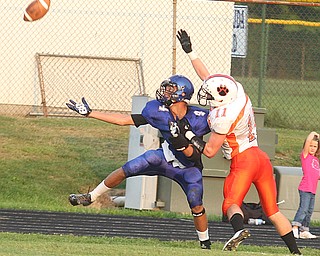 FOOTBALL - Daniel Ebert of Howland battles with (4) Elijah Henderson for the ball during thier game Thursday night in Cortland. - Special to The Vindicator/Nick Mays