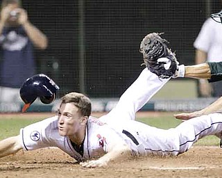 Cleveland Indians' Cord Phelps slides safely into home plate to score the game-winning run as Oakland Athletics catcher Kurt Suzuki is late on the tag in the 16th inning in a baseball game, early Thursday, Sept. 1, 2011, in Cleveland. The Indians won 4-3. (AP Photo/Tony Dejak)