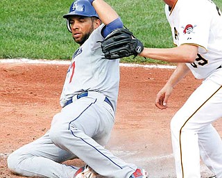 Los Angeles Dodgers' James Loney, left, scores on a wild pitch by Pittsburgh Pirates pitcher Jason Grilli, right, during the seventh inning of a baseball game in Pittsburgh Thursday, Sept. 1, 2011. The Dodgers won 6-4. (AP Photo/Gene Puskar)