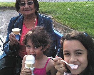 Catalina Lugo of Campbell is savoring ice cream from the Boardman Handel's with great-granddaughters Amaya and Aliya Abeid of New Middletown.