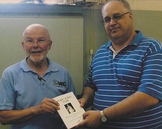 The Rev. Bob Bonnot, left, is presented with a copy of one of two books he has authored on Pope John XXIII by fellow Rotarian Tom Baringer at Struthers Rotary’s recent meeting. Father Bonnot was asked to autograph the book to donate to a library of his choice.