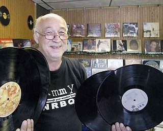 Underdog Records owner Ron “Sonny” Hrehovcik displays four of the thousands of albums he has in his store. His assortment of records ranges from Frank Sinatra to Ozzy Osbourne.