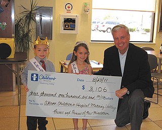 Cordell Hanley, known as Corey, 5, and Lillie Zoldan, 6, the prince and princess of New Middletown, present a check for Akron Children’s Hospital Mahoning Valley to ACH President and Chief Executive Officer William Considine. Lillie, the daughter of Neal and Lesa Zoldan of New Springfield, and Corey, the son of Larry and Michelle Hanley of New Springfield, claimed their royal titles by raising the most funds for the hospital in July among contestants who sold lemonade, or had garage sales, neighborhood carnivals or other activities. They also served as grand marshals during the New Middletown National Night Out parade Aug. 2, and they will be making other public appearances throughout the community. The July fundraiser was coordinated by Kerri Bernard, Connie Brinker and Melissa Guzman, all of Hair Galleria in New Middletown.