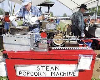 Thomas Hacon of Austintown makes popcorn at his booth at the Canfield Fair. The octogenarian has been making popcorn at the fair for nearly 20 years. His machine is powered by compressed air and LP gas, patterned after a steam machine he saw when he was a boy. He gives samples away.