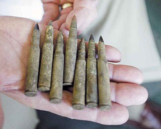 Dr. Donald K. Allen of Youngstown, a veterinarian and a military veteran, shows off 30-caliber bullets recovered from the Battle of the Bulge battlefield in Belgium. He has written a book to let people know what happened to their loved ones listed as missing in action.