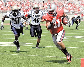 Ohio State tight end Jake Stoneburner (11) heads to the end zone for a touchdown after catching a pass from quarterback Joe Bauserman as Akron cornerback Emmanuel Lartey (31) and linebacker Blake Fraley (46) pursue during the second quarter of an NCAA college football game in Columbus, Ohio on Saturday, Sept. 3, 2011. (AP Photo/Amy Sancetta)