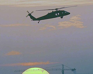 FILE - In this Nov. 14, 2006 file photo, the sun sets as a Black Hawk helicopter hovers over Baghdad's protected Green Zone. America's wars since the attacks of Sept. 11, 2001 have been a boon for the maker of Black Hawks. Sales at the Stratford, Conn.-based Sikorsky Aircraft Corp., more than doubled in five years, to $6.7 billion in 2010, due in large part to the company’s military business that includes the Black Hawk. (AP Photo/Darko Bandic, File)