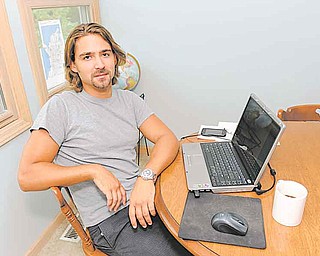 In this Sept. 2, 2011 photo, Ryan McGrath, 26, poses in his home in Michigan City, Ind. McGrath has been working part time designing web sites for small businesses but wants steadier full-time work. (AP Photo/Joe Raymond)