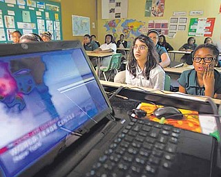FILE -Wednesday, May 4, 2011 file photo, Ivy Preparatory Academy sixth graders Simin Savani, left, and Hannah Baker, right, watch a news reel of the 9/11 terrorist attacks in school in Norcross, Ga. Educators are finding it more difficult each year to teach about Sept. 11, 2001, as students remember less and less _ or nothing at all _ about the terrorist attacks. (AP Photo/David Goldman)