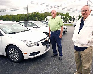 Bob Thomas, left, of North Jackson and Ray Milstead of Austintown talked Tuesday at the Spitzer Chevrolet dealership in North Jackson about driving their Chevrolet Cruzes. Thomas and Milstead each bought one of the first Cruzes last fall. The Lordstown-built car celebrates the anniversary of its launch Thursday.