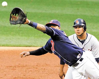 Cleveland Indians first baseman Carlos Santana leaps in front of Detroit Tigers' Jhonny Peralta but can't catch a line drive for an RBI single by Tigers' Don Kelly during the first inning of a baseball game Tuesday, Sept. 6, 2011, in Cleveland. (AP Photo/Mark Duncan)