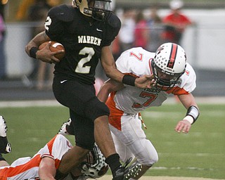 ROBERT K. YOSAY | THE VINDICATOR --..Warrens #2 Jalyn Powell tries to Break the tackle of #32 Dan Russell and Howlands #7 Zach WIlson during first quarter action as they brought him down at the line . Howland Tigers vs Warren G Harding Raiders @ Warren ..--30-..(AP Photo/The Vindicator, Robert K. Yosay)