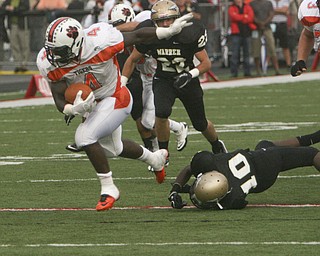 ROBERT K. YOSAY | THE VINDICATOR --..Howlands #4 Deveon Smith sends #10 Warren Corey Cayson to the ground and #22 Kyle Copley can only look as he takes off for a touchdown --.Howland Tigers vs Warren G Harding Raiders @ Warren ..--30-..(AP Photo/The Vindicator, Robert K. Yosay)