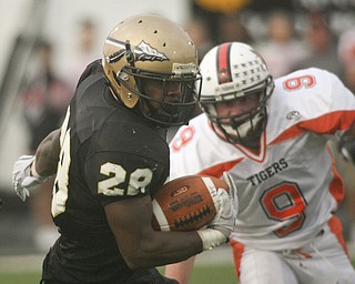 ROBERT K. YOSAY | THE VINDICATOR --..Warren #28 (NO NAME IN THE PROGRAM) Twists and turns away from Howlands #9 Rob Klose during first quarter action .. Howland Tigers vs Warren G Harding Raiders @ Warren ..--30-..(AP Photo/The Vindicator, Robert K. Yosay)