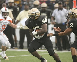 ROBERT K. YOSAY | THE VINDICATOR --..Warren #28 LeShun Daniels takes the hand off from #2 Jalyn Powell as Howlands #9 Rob Klose looks on.. Le Shun went for 5 yards in first quarter action in Warren..Howland Tigers vs Warren G Harding Raiders @ Warren ..--30-..(AP Photo/The Vindicator, Robert K. Yosay)