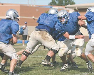 Anthony Pesce, second from right, rushes through the line at a recent Hubbard High School practice.