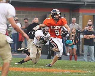 FOOTBALL - (9) Brian Johnson tries to get away from (3) Joey Smith during thier game Friday night in Springfield. - Special to The Vindicator/Nick Mays
