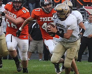 FOOTBALL - Lowellville QB (7) Randy Pavlicko is chased from the pocket by (47) Lenard Lewis and (66) Gabe Crowe during thier game Friday night in Springfield. - Special to The Vindicator/Nick Mays