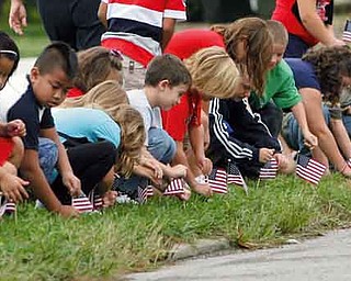 Second-graders place flags along Stadium Drive to honor those who served their country.