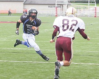 FOOTBALL -(3) Anthony Abeid of YCS makes a move on (82) Tim Cross for a touchdown run during thier game Saturday afternoon in Canfield. - Special to The Vindicator/Nick Mays