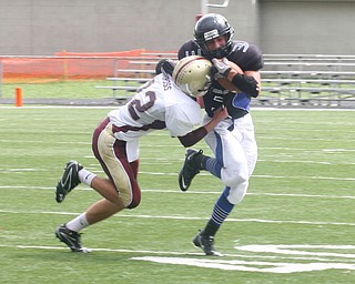 FOOTBALL -(3) Anthony Abeid of YCS tries to fight off (82) Tim Cross during thier game Saturday afternoon in Canfield. - Special to The Vindicator/Nick Mays