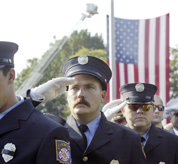 William D. Lewis | The Vindicator Jackson Twp Fire Dept.Randy Wilson Jr. salutes during a Sunday observance of the 9/11 attacks at the Austintown 9/11 Memorial Park. Hundreds of area residents and representatives from many fire departments where on hand for the event.