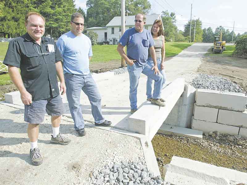Grace Haynie, far right, stands on a bridge leading to her familyÕs property off Niles-Vienna Road. With her, from left, are Bob Kolat, Jeff Jardine and Eugene Macek of Jardine Builders and Septic System in Niles, which helped to replace an old bridge at the site..