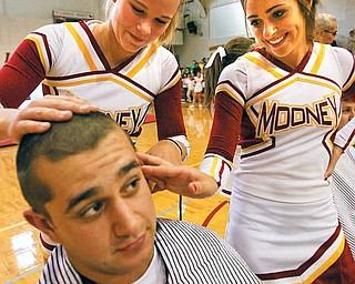 Carmen Lanzo has his hair clipped by his sister, Kiersten Lanzo, and Eva Colwell at a rally Thursday for the Mooney football team. The rally also was designed to show solidarity with Mooney senior Dante DelSignore who has battled cancer for four years and is receiving his fourth round of chemotherapy in his battle against osteosarcoma.