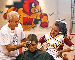 Nick Colla and Callie Tofi l clip Austin Trgovicich’s hair at a rally for the football team and for student Dante DelSignore who has battled cancer for four years.