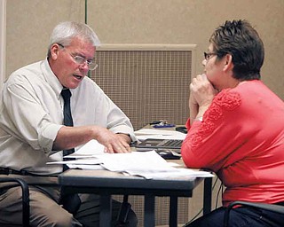 Eloisa Luminiello of Austintown consults with Ken Jones, an appraiser with Integrity Appraisal Services Inc. of Niles, concerning the tentative valuation of her property at Mahoning County’s reappraisal information center at Oakhill Renaissance Place, Youngstown. The consultations continue through Oct. 7.
