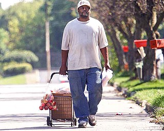 Darren Moore of Cohasset Drive walks home with his shopping cart full of fresh food and drinks from Jordan’s Market on Market Street on Youngstown’s South Side. The city is rated as the third worst urban “food desert’’ in the U.S.