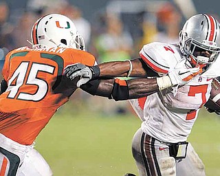 Ohio State running back Jordan Hall (7) runs as Miami linebacker Ramon Buchanan (45) defends during the second quarter of an NCAA college football game in Miami, Saturday, Sept. 17, 2011. (AP Photo/Lynne Sladky)