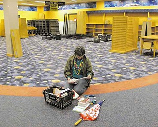 FILE - In this Sept. 15, 2011 file photo, Sue Schmidt of Shaker Heights, Ohio, sits on the floor to sort through her potential purchases in a nearly-empty Borders bookstore in Solon, Ohio. This Borders store was scheduled to close its doors for good at the end of the day. (AP Photo/Amy Sancetta, File)