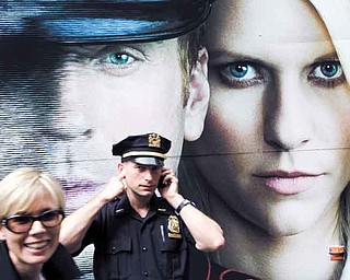A police officer covers his ears to block out noise from demonstrators gathering to call for the occupation of Wall Street, Saturday, Sept. 17, 2011, in New York. According to their website, the mission of the leaderless resistance movement is to flood thousands of people into lower Manhattan, set up beds, kitchens, peaceful barricades and occupy Wall Street for a few months in order to persuade President Barack Obama to establish a commission to end "the influence money has over representatives in Washington." (AP Photo/Frank Franklin II)