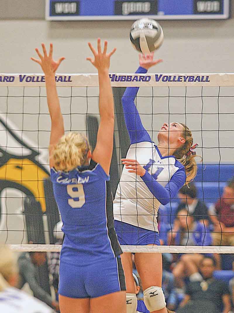 (11) Maris Sarisky of Hubbard goes up for the spike as (9) Calli Schmitt tries for the block Monday evening.