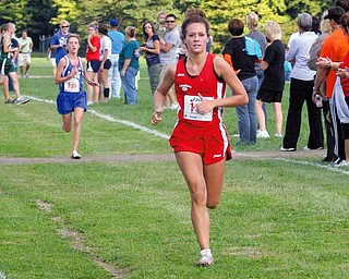 Ashley Lydic of Columbiana and McKinsie Klim of Poland cross the fi nish line on top Tuesday afternoon in Canfi eld. Lydic placed first overall, while Klim’s Bulldogs were the top overall girls team.