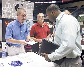 Kevin Young, left, a maintenance supervisor for V&M Star, speaks with Michael Cook, 37, of Youngstown about job opportunities at the company at the sixth annual Ohio-Penn Interstate Job Expo at the Covelli Centre.