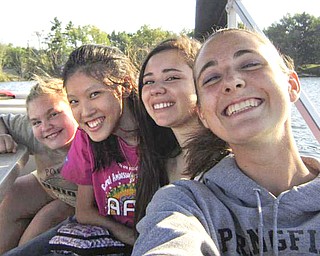 Enjoying a boat ride and some fun at a get-acquainted meeting Aug. 28 at Lake Milton were, from left, Kayla Windsor, an AFS host sister; Paticha “Pie” Areepipatkul from Thailand; Catalina Rojas Rodriguez from Chile; and Sarah Gabrick, another AFS host sister.