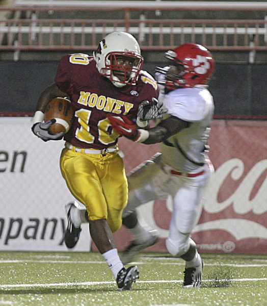 JESSICA M. KANALAS | THE VINDICATOR ..Mooney's junior running back Justus Ellis-Moore avoids a tackle from junior defensive back Quashawn Lister of the Red Lion Christian Academy during the first quarter of Saturday night's game at YSU stadium. ..-30