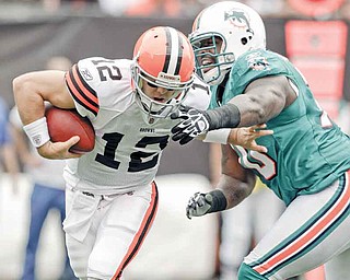Miami Dolphins defensive end Kendall Langford, right, pressures Cleveland Browns quarterback Colt McCoy in the first quarter in an NFL football game on Sunday, Sept. 25, 2011, in Cleveland.  (AP Photo/Mark Duncan)