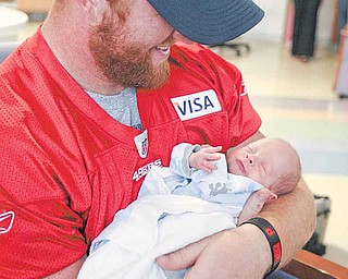 The 49ers’ Bruce Miller holds 3-week-old Michael McCall, who was born 32 weeks premature.