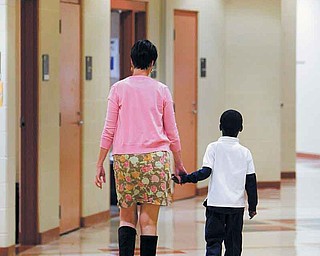 A teacher at Taft Elementary School in Youngstown accompanies a student down the hall. Taft administrators say students need to know that the school is a safe place and that someone there cares about them.