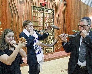Rabbi Joseph Schonberger of Temple El Emeth in Liberty leads the sounding of the shofar (ram’s horn) during a practice session with Meryl Schor, 14, left, and Korey Burdman, 15. The traditional sounding of the ram’s horn will be part of High Holiday services. Rosh Hashanah begins at sundown tonight. 