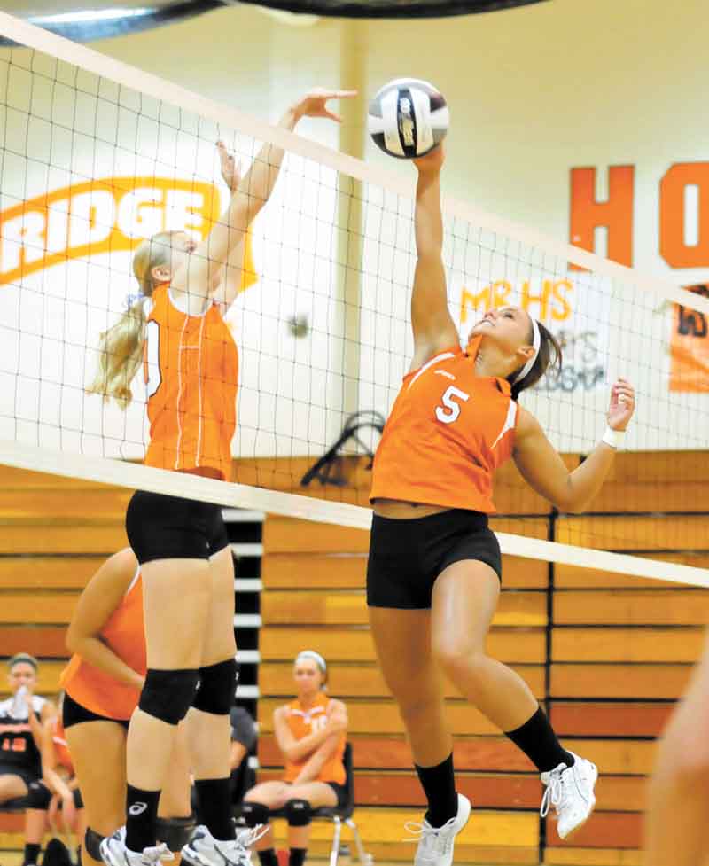 Mineral Ridge’s Lea Whitmer (5) tries to make a play after Springfield’s Morgan Buchenic, sends the volleyball onto the Mineral Ridge side during Tuesday’s match at Mineral Ridge High. The Tigers won in three games.