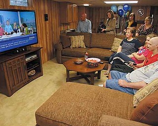 Dante DelSignore relaxes Thursday in his new “man cave” with his dad, Gregory DelSignore, sister Tina DelSignore and mom Carrie DelSignore. The plush couch and tables were donated by Broyhill furniture through Goldsteins Furniture & Bedding on U.S. Route 224.
