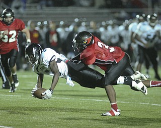 ROBERT K. YOSAY | THE VINDICATOR..#5 East Valentino Sewell jumps and stretches for yardage by #3 Canfield Bryce Jackson ..East Panthers at Canfield Cardinals .....-30