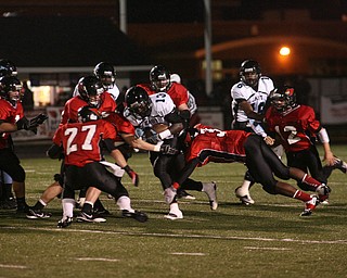 ROBERT K. YOSAY | THE VINDICATOR..East #13 George LeFlore as he was stopped by #27 Ben Angelo #3 Bryce Johnson #12 Mike Hughes ... ..East Panthers at Canfield Cardinals .....-30