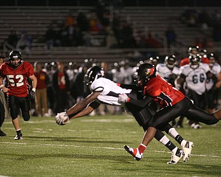 ROBERT K. YOSAY | THE VINDICATOR..#5 East Valentino Sewell jumps and stretches for yardage by #3 Canfield Bryce Jackson ..East Panthers at Canfield Cardinals .....-30